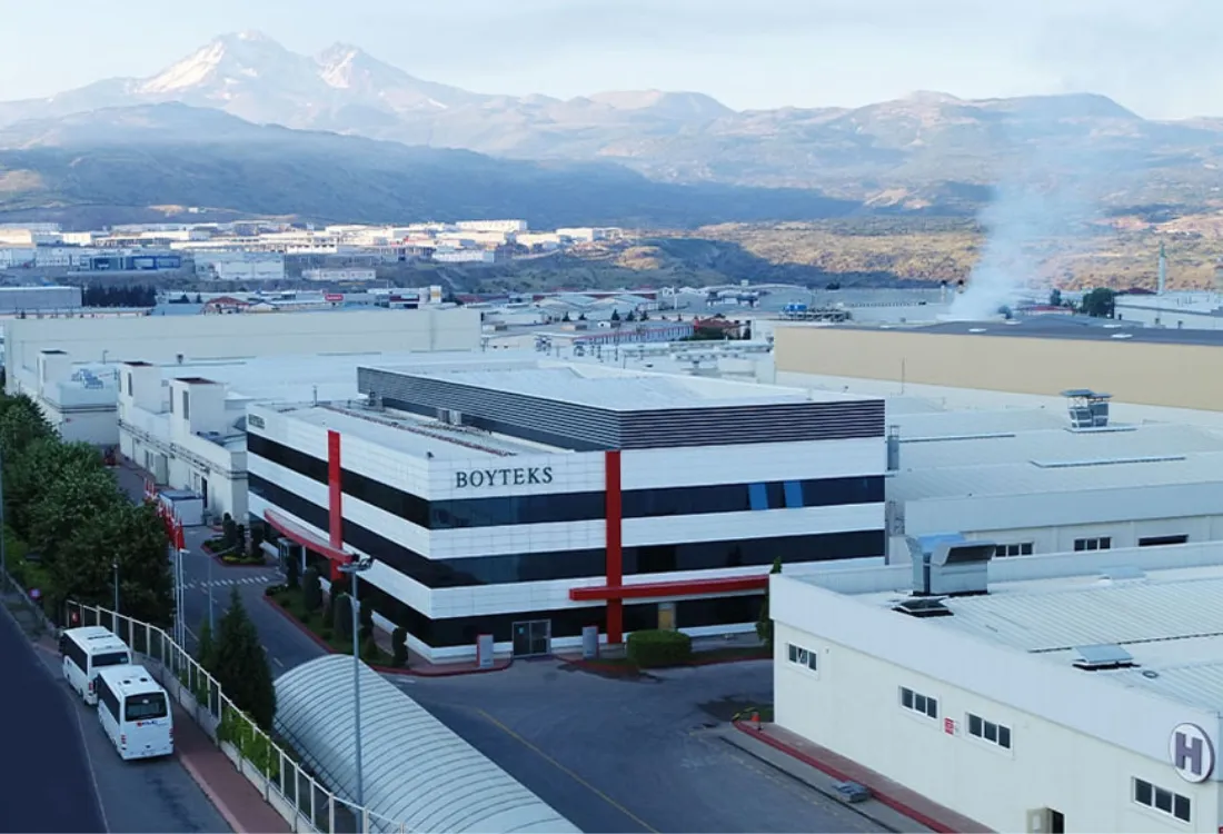 Boyteks factory building in Turkey with mountains in the background