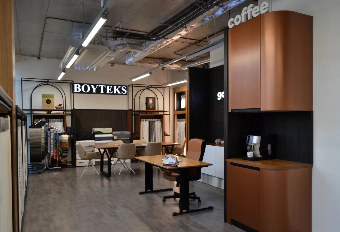 Showroom with fabric samples, a seating set, and a coffee machine in the corner